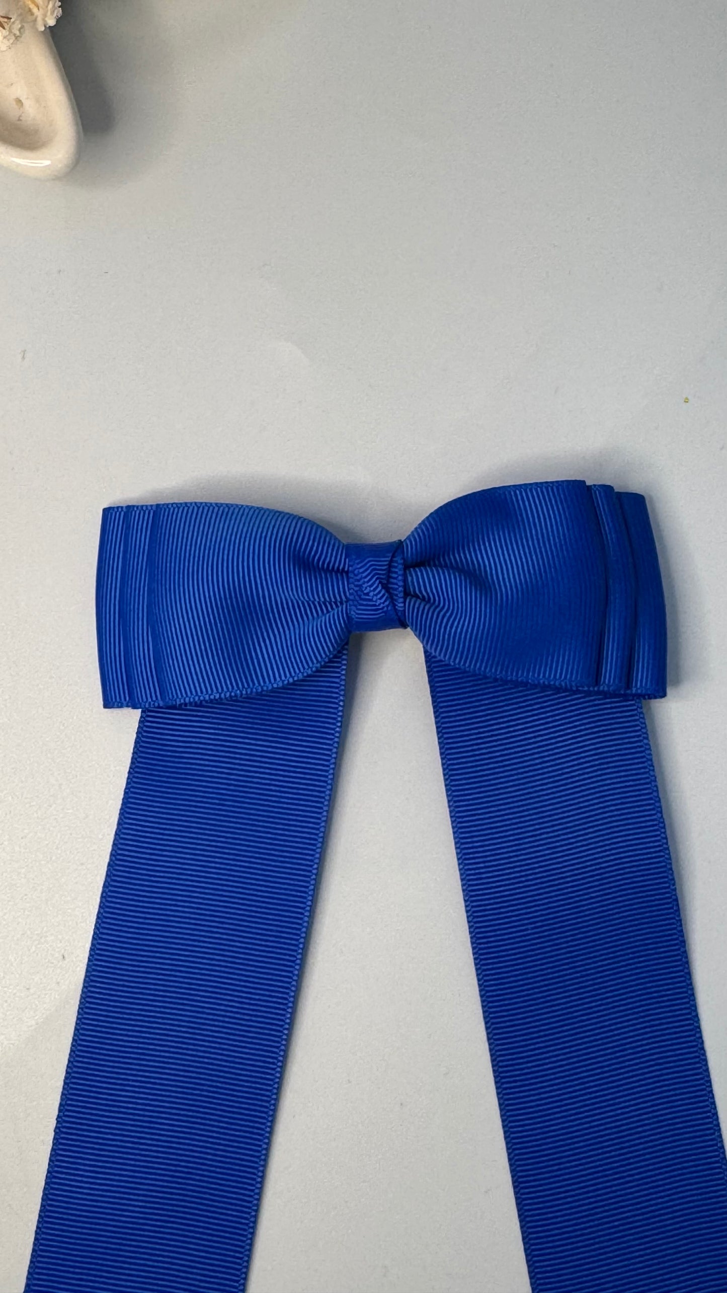 Green grosgrain long-tail bow with floral trim.