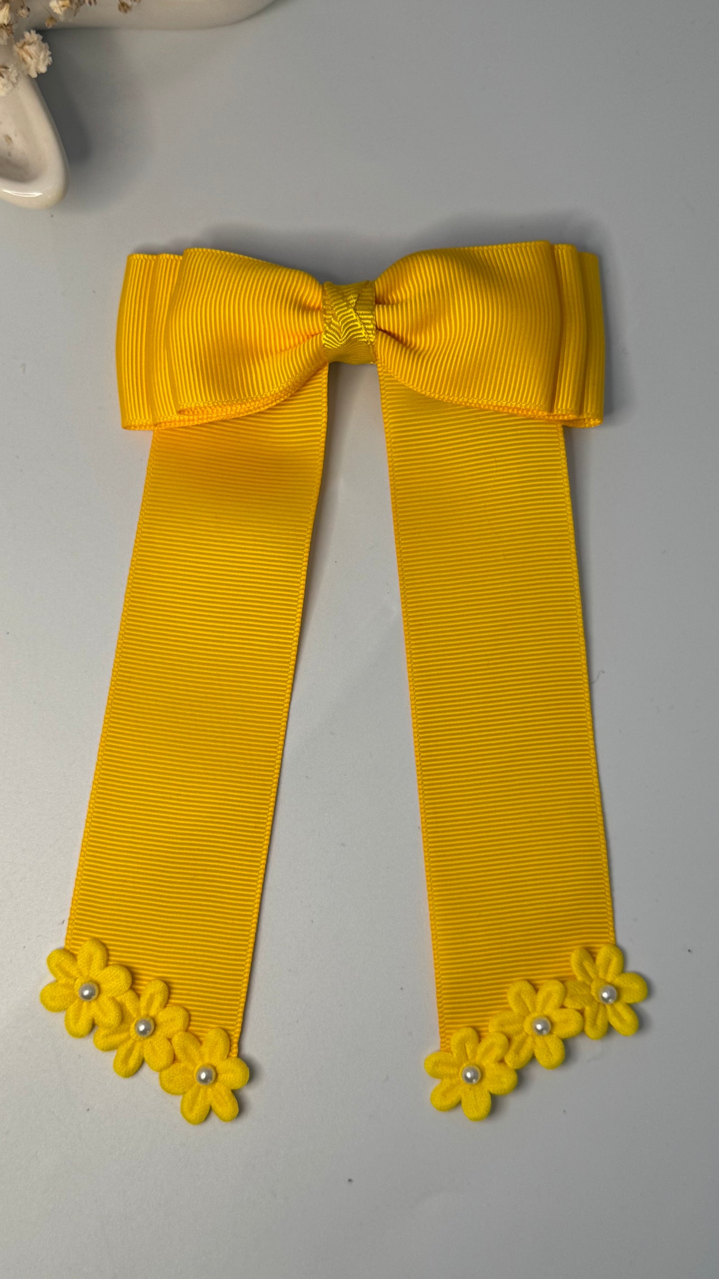 Green grosgrain long-tail bow with floral trim.