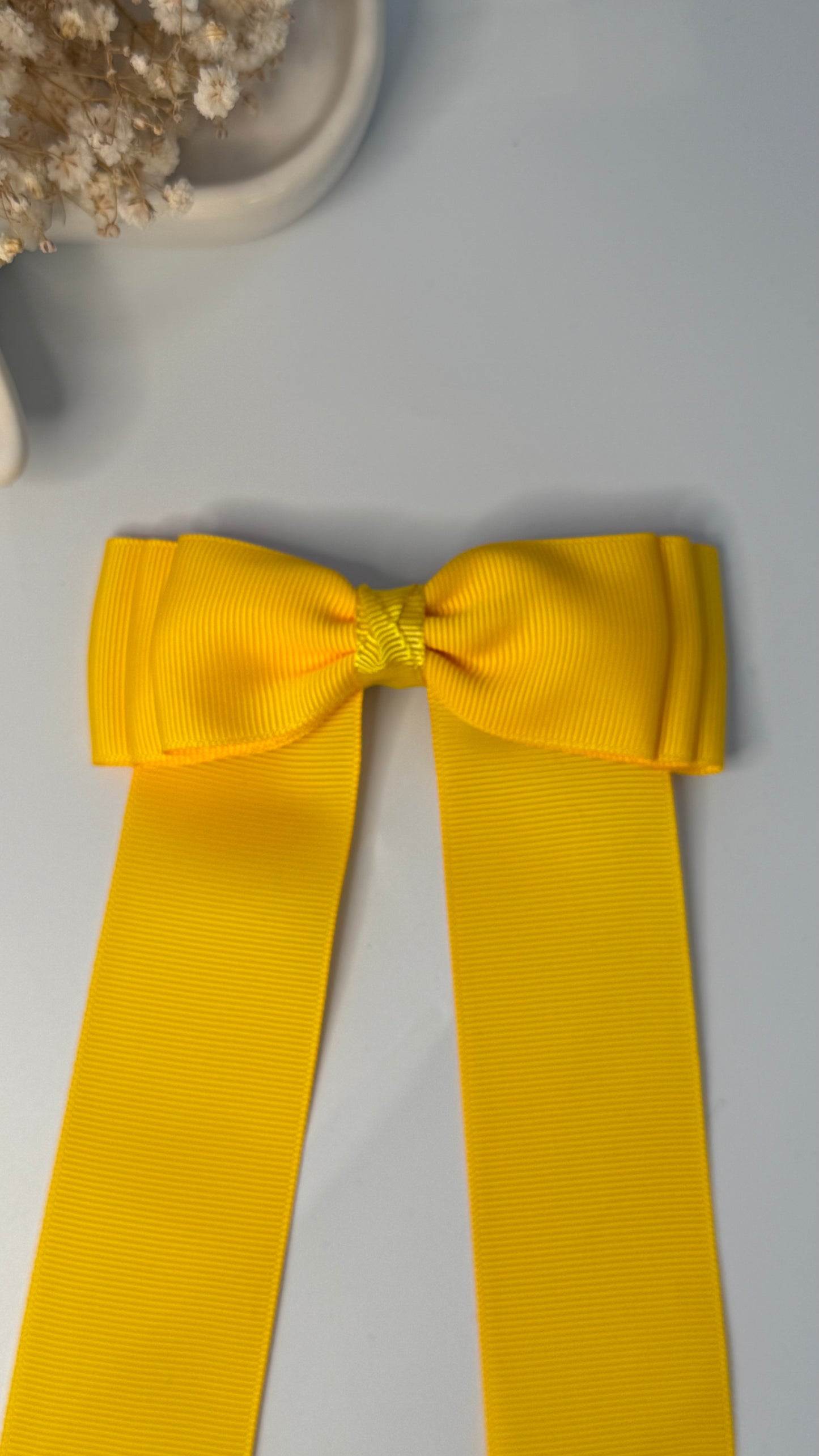 Green grosgrain long-tail bow with floral trim.