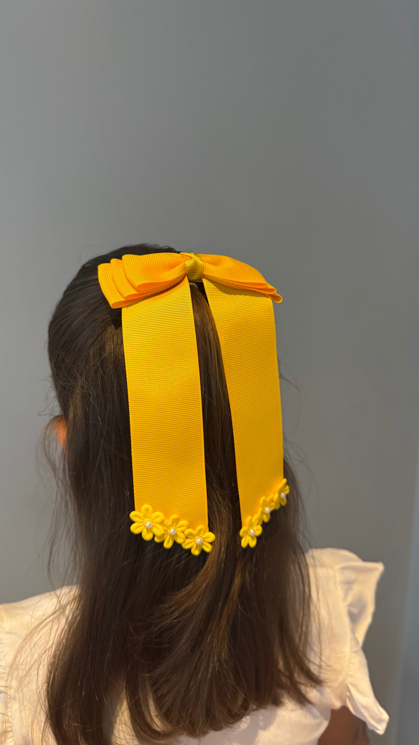 Green grosgrain long-tail bow with floral trim.