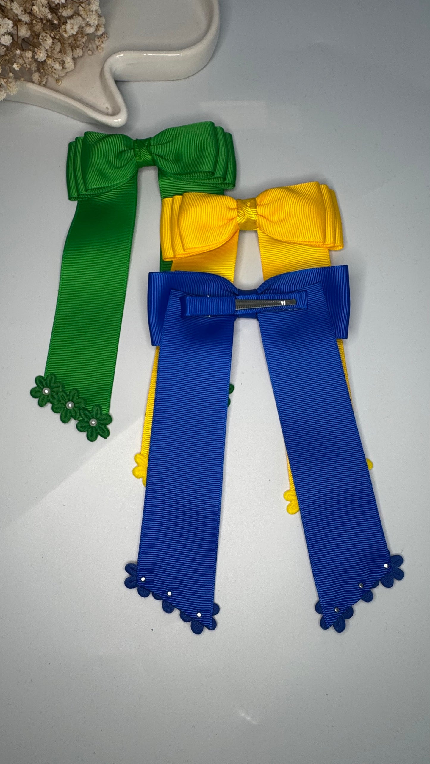 Green grosgrain long-tail bow with floral trim.